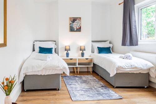 a bedroom with two beds and a desk and a window at Charming 2-Bedroom Flat with a Garden and Free Parking at Abingdon in Oxford