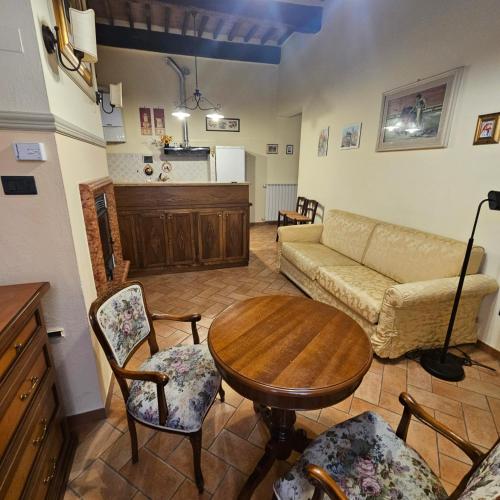 a living room with a couch and a table and chairs at Opio Nel Corso 47 in Montepulciano