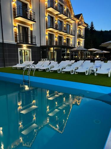 um hotel com piscina em frente a um edifício em Konopka Forest Home & SPA em Bukovel