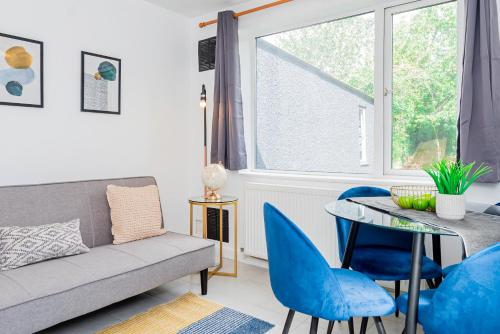 a living room with a couch and a table and chairs at Charming 2-Bedroom Flat with a Garden and Free Parking at Abingdon in Oxford