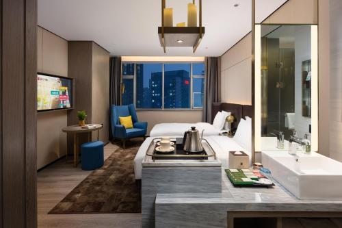 a hotel room with a bed and a sink and a bathroom at ECHARM Plus Hotel - Hangzhou Binjiang Starlight Avenue in Hangzhou