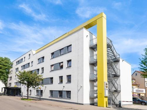 um grande edifício branco com um poste amarelo em B&B Hotel Heilbronn em Heilbronn