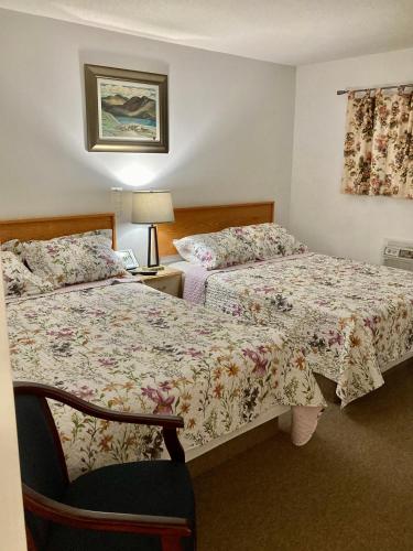 a hotel room with two beds and a lamp at Motel 99 in Grand Forks