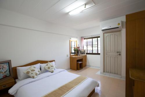una camera bianca con letto e bagno di D haus Ngamwongwan Residence a Nonthaburi