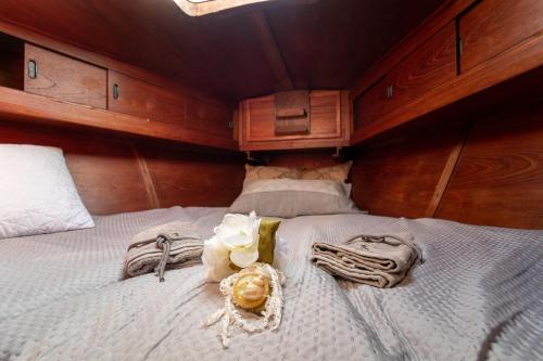 a bedroom with a bed with towels and flowers on it at Quo Vadis Yacht in Bari