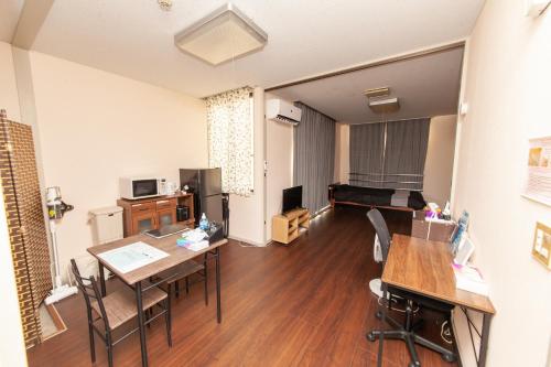 Big Stone Tsukuda 41平米 R303 في أوموري: غرفة معيشة مع طاولة وغرفة طعام