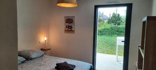 a bedroom with a bed and a door with a window at Villa face à la mer in Binic