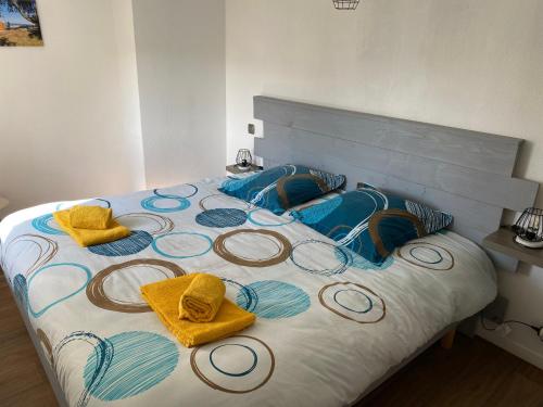 Una cama con toallas y almohadas encima. en Maison à 300 m de la plage., en La Cotinière