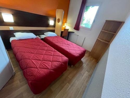 Habitación de hotel con 2 camas y mantas rojas en Premiere Classe Rungis - Orly, en Rungis