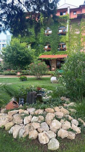 a garden with rocks in front of a building at Oleander House and Tennis Club in Sunny Beach