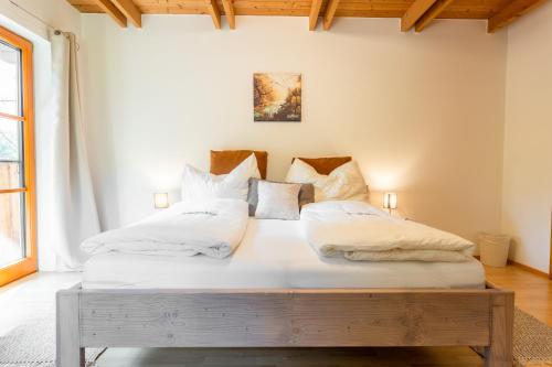 een slaapkamer met een bed met witte lakens en kussens bij NaturparkResort Zu Hause in Sankt Gallen