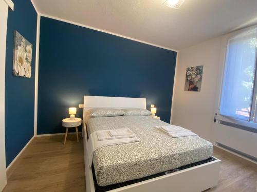 1 dormitorio con cama y pared azul en Basiglio - Residenza Sorgente en Basiglio