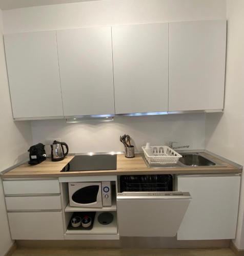 a small kitchen with white cabinets and a sink at Basiglio - Residenza Sorgente in Basiglio