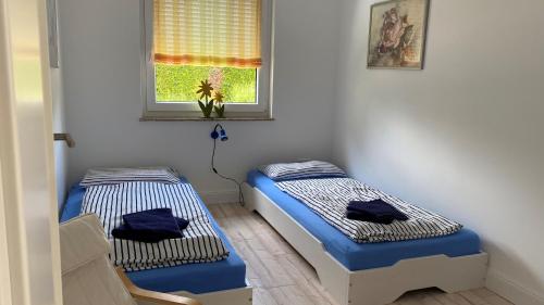 two twin beds in a room with a window at Ferienwohnung Lilienthal in Lilienthal