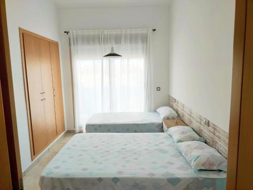 a bedroom with two beds and a window at Resort Home 10 in Sant Jordi