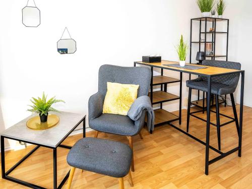 a living room with a table and a chair and a desk at Business Appartements Arnstadt OT Marlishausen in Arnstadt