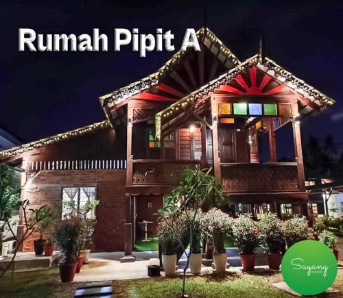 a building with plants in front of it at night at Sayang Di Kaki Bukit Homestay Near Icon City Bukit Mertajam in Bukit Mertajam