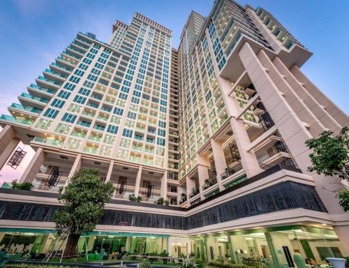 a large building with trees in front of it at City Garden Tower by Pattaya Holiday in Pattaya South