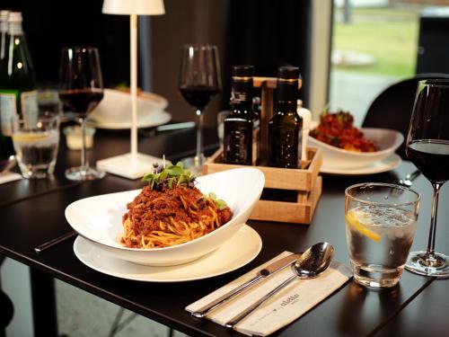 a table with a bowl of food and glasses of wine at aletto Hotel Potsdamer Platz in Berlin