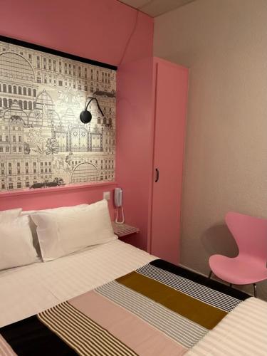 a pink bedroom with a bed and a pink chair at Hôtel de la Croix-Rousse in Lyon