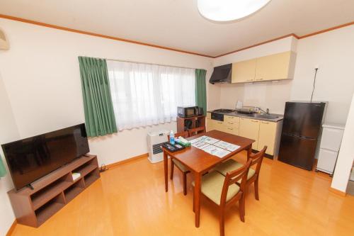 a kitchen with a table and chairs in a room at Restful Tsukuda in Aomori