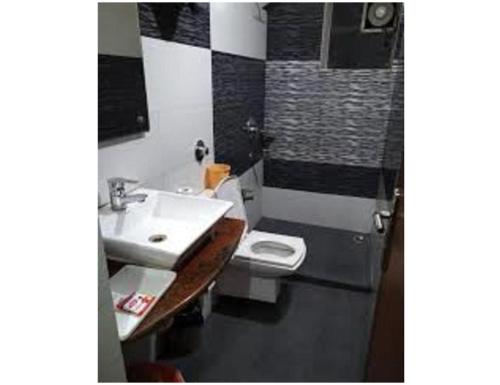 a bathroom with a sink and a toilet at Hotel Shambhavi, Singrauli in Singrauli