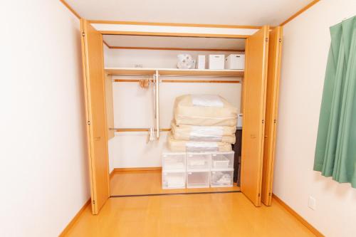 a walk in closet with a door open with towels at Restful Tsukuda in Aomori