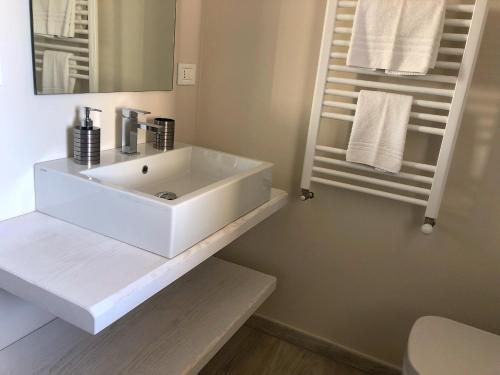 Un baño blanco con lavabo y espejo. en Camere Paolina, en Foligno