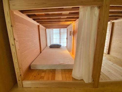 una casetta con un letto in una stanza di Guesthouse Imaichi ゲストハウス今市マチナカ a Nikko