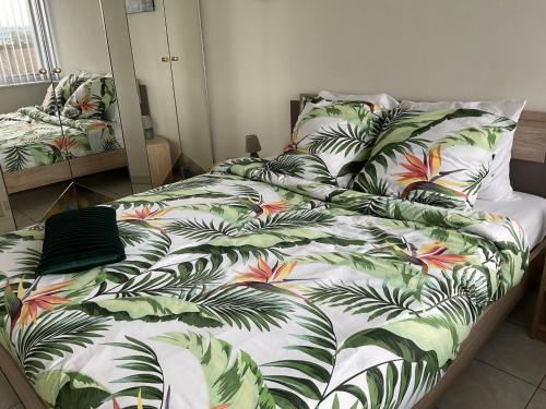 a bedroom with a bed with a tropical print at Micheline's plekje in Ostend