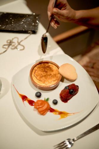 a person eating food on a white plate on a table at Herbert Park Hotel and Park Residence in Dublin