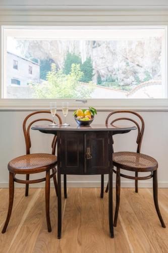 a table with two chairs and a bowl of fruit on it at La Casa del Sarto Amalfi in Amalfi