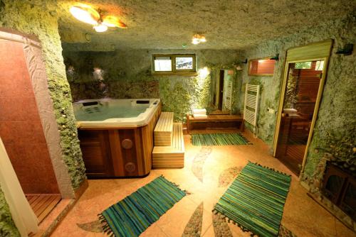 een badkamer met een bad met groene muren en vloeren bij Arciau Juros in Palanga