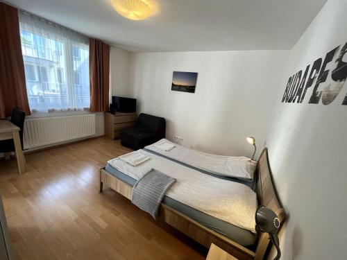 een slaapkamer met een bed en een stoel erin bij Garay Utca - Unit A52 in Boedapest