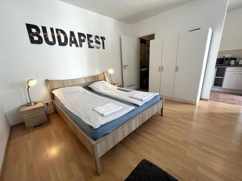 een slaapkamer met een bed met een bord aan de muur bij Garay Utca - Unit A52 in Boedapest