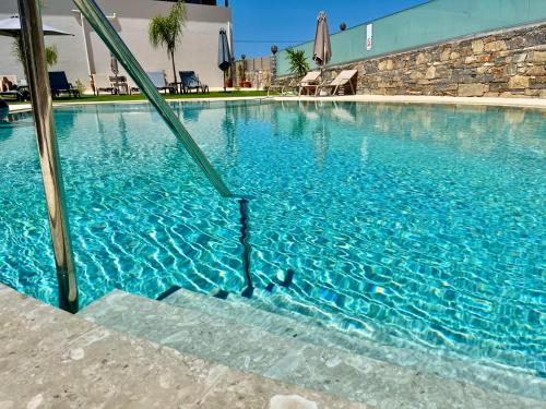 a large blue swimming pool with blue water at Luxury Suites in Stavromenos in Stavromenos