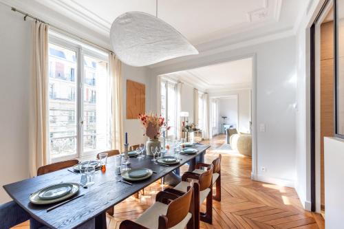 une salle à manger avec une longue table et des chaises dans l'établissement Luxury apartment - 5 min walk from Champs-Elysées, à Paris