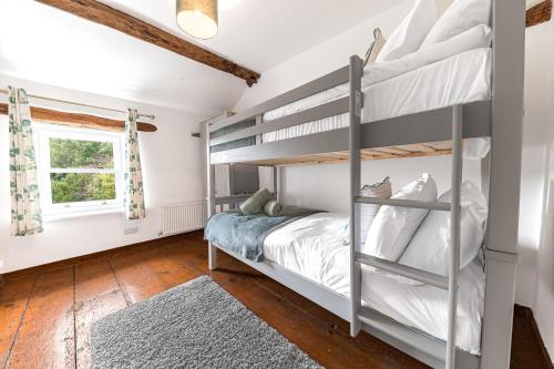 ein Schlafzimmer mit Etagenbetten und einem Fenster in der Unterkunft Knott House Farm in Keswick