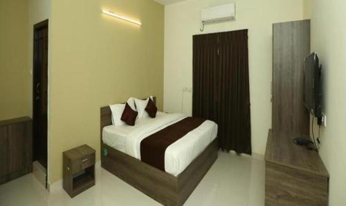 ein Schlafzimmer mit einem Bett und einem TV in der Unterkunft FabHotel I Live Inn in Chennai