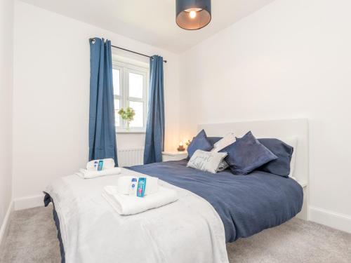 um quarto com uma cama azul com toalhas em Pass the Keys Bramhope Haven em Leeds