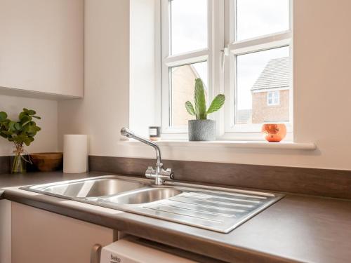 a kitchen counter with a sink and a window at Pass the Keys Bramhope Haven in Leeds