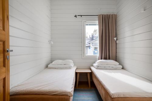 two beds in a room with a window at Levilehto Apartments in Levi