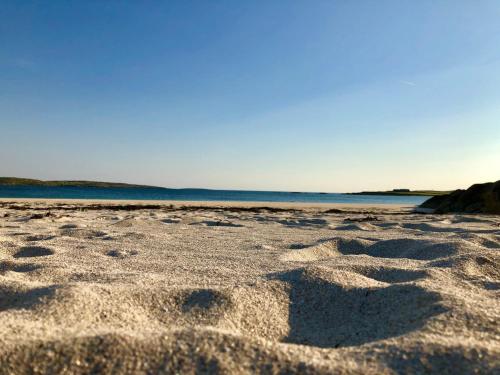 a sandy beach with the ocean in the background at Bruíon Connemara in Cleggan
