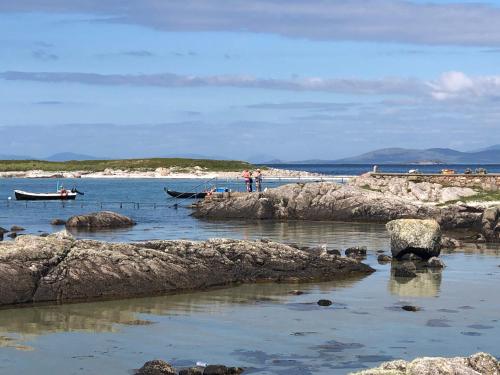 a group of people standing on a beach near the water at Bruíon Connemara in Cleggan