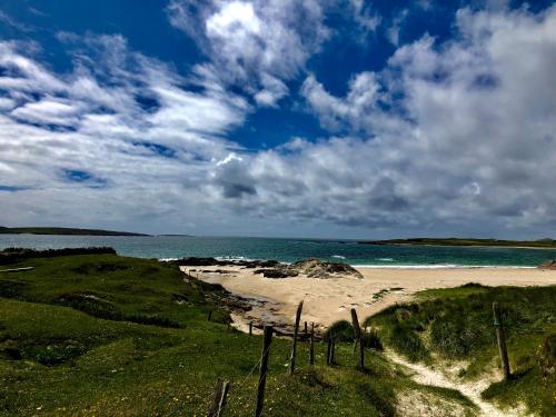 a sandy beach with the ocean in the background at Bruíon Connemara in Cleggan