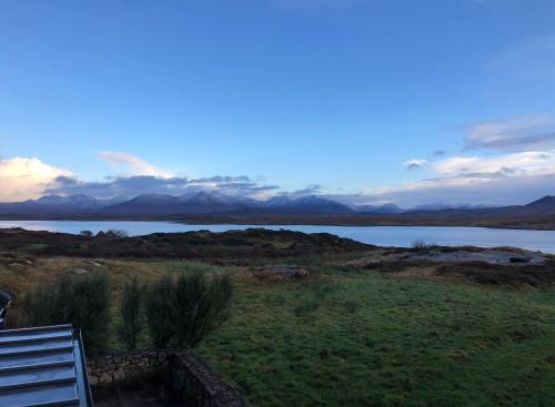 a bench in a field with a view of a lake at Bruíon Connemara in Cleggan