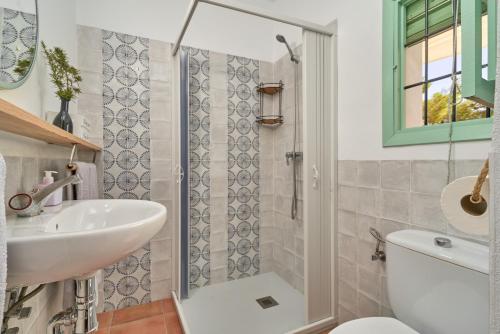 a bathroom with a sink and a toilet and a shower at Cortijo de Arriba in Frigiliana