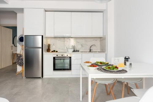 a kitchen with white cabinets and a table with food on it at PROPAN CITY SUITES in Volos