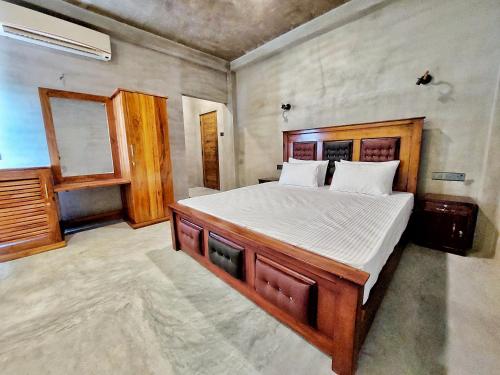 a bedroom with a large wooden bed in a room at Catch Up Dambulla in Dambulla