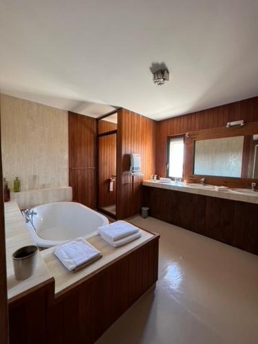 a large bathroom with a tub and a sink at Villa L'Arbousière in Porto-Vecchio